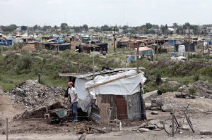 A man walks next to his makeshift home in 2008 in Buenos Aires, Argentina. The U.S. Supreme Court denied an appeal by Argentina in a case in which a hedge fund has sued the country for $1 billion, meaning the country will be forced to turn over information about financial assets in New York banks and face the possibility of not providing development aid for the country's poorest residents. (CNS/Cezaro De Luca, EPA)
